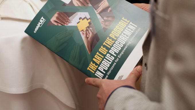 Person holding a booklet titled "The Art of the Possible in Public Procurement: New Horizons for Empowering Innovation," exploring insights from the Public Procurement Act.