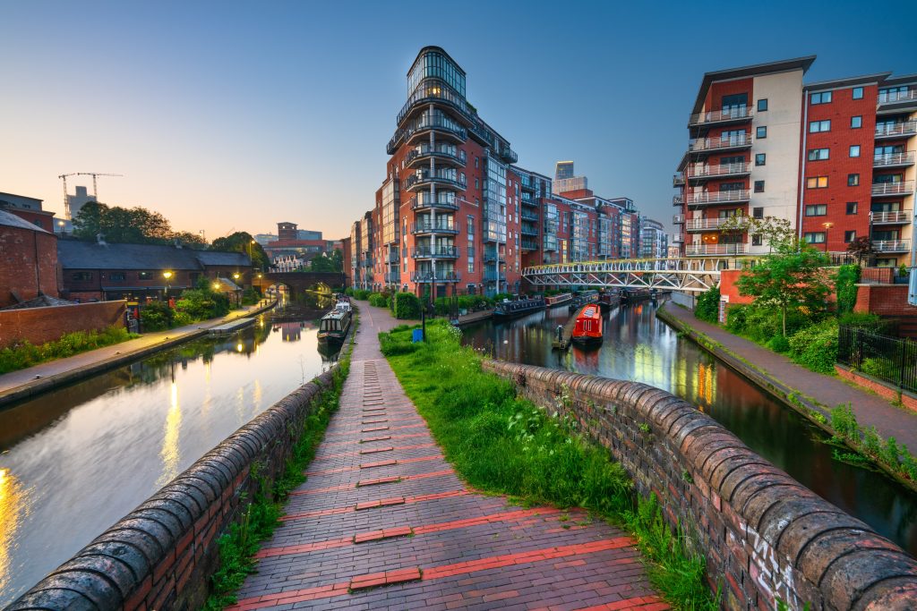 beautiful canal scene in the West Midlands. Modern red-brick apartment buildings line the water.