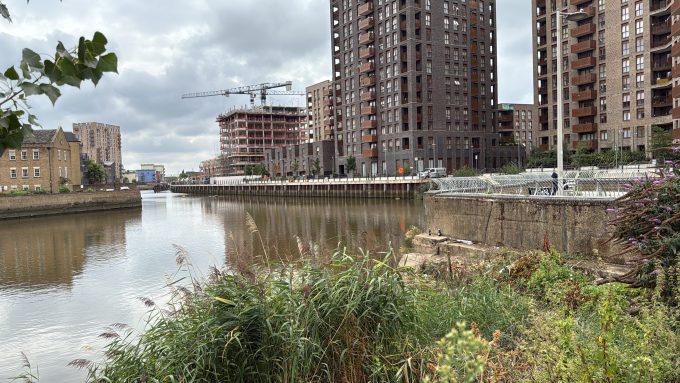 The River Rhoding site showing a canal, several high rise buildings and foliage. The site is the viewing platform site.