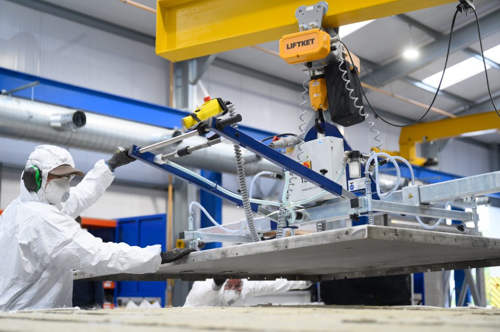 HS2 cross-passage doors being manufactured at the Booth factory in Bolton. Person in protective gear working with large machinery.
